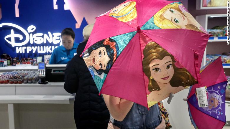 A shopper opening an umbrella featuring Disney Princesses at the Central Children's Store in Moscow's Lubyanka Square in 2017.