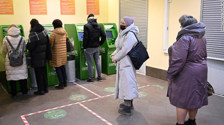 8128835 28.02.2022 People stand in line at the ATM of the Sberbank at the GUM State Department Store, in Moscow, Russia. Invasion of Ukraine sent the ruble plummeting, leading uneasy people to line up at banks and ATMs. Ramil Sitdikov / Sputnik  via AP