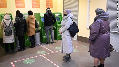 8128835 28.02.2022 People stand in line at the ATM of the Sberbank at the GUM State Department Store, in Moscow, Russia. Invasion of Ukraine sent the ruble plummeting, leading uneasy people to line up at banks and ATMs. Ramil Sitdikov / Sputnik  via AP