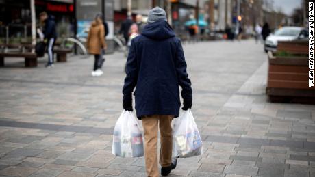 A shopper carries his purchases in Walthamstow, east London, on February 13.