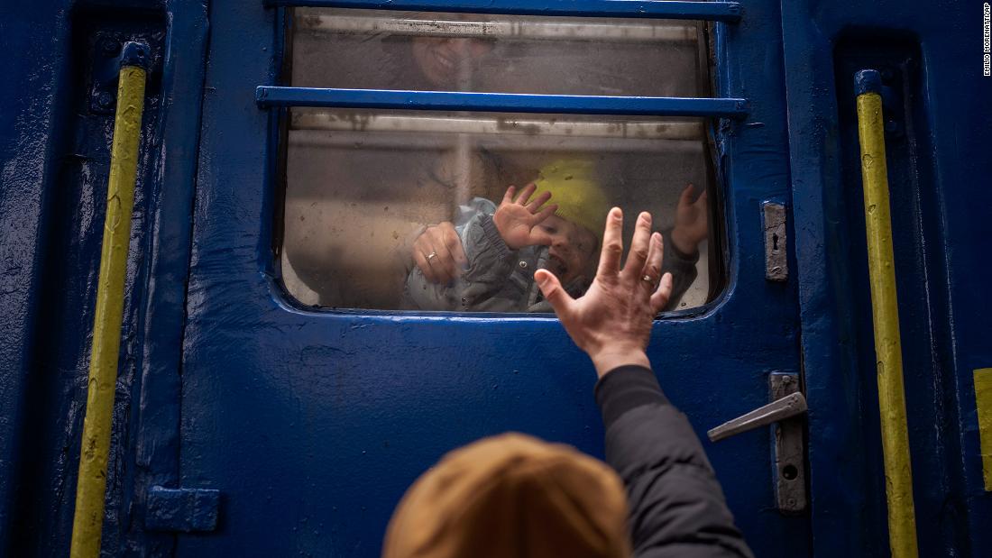 A man says goodbye to his wife and son at a train station in Kyiv on Thursday, March 3.