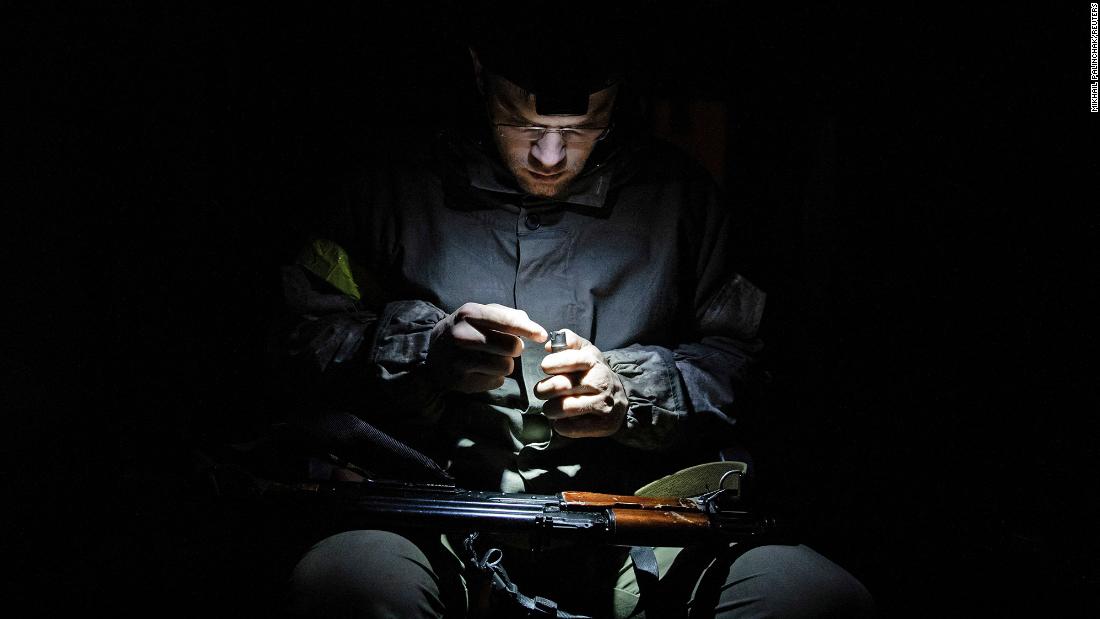 A member of Ukraine&#39;s Territorial Defense Forces sits with a weapon in Kyiv on Wednesday, March 2.