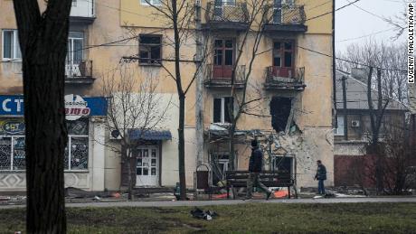 A man passes an apartment building hit by shelling in Mariupol, Ukraine on Wednesday. 