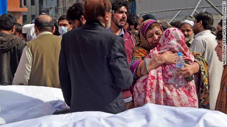 Crowds mourn the death of their relatives outside a hospital following a blast at a mosque in Peshawar on Friday.