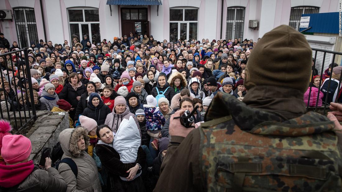 A member of the Ukrainian military gives instructions to civilians in Irpin on March 4. They were about to board an evacuation train headed to Kyiv.