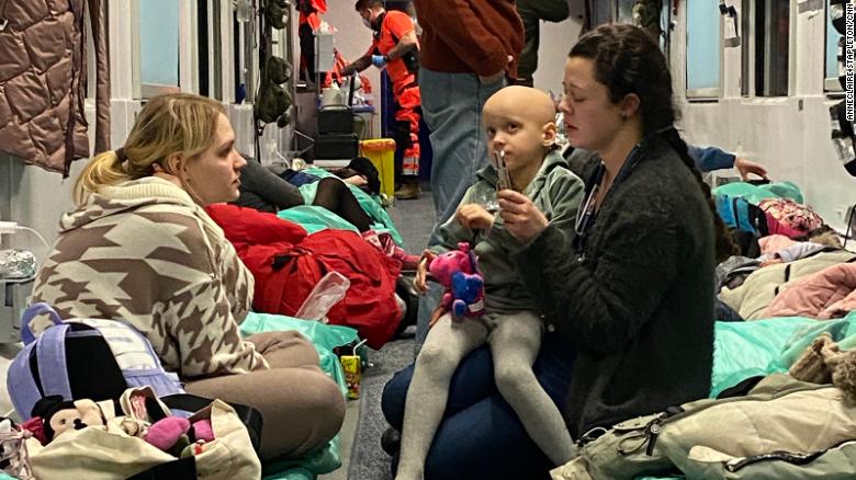 Szuszkiewicz sits with six-year-old Sophia, who clutches a toy given to her by volunteers on the train.