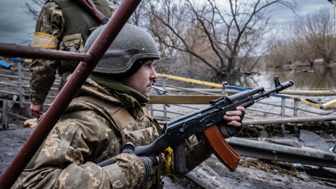 Ukrainian soldiers react to the sound of an incoming missile at the Irpin River, on the outskirts of Kyiv, on March 5.