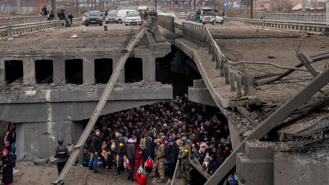 Ukrainians crowd under a destroyed bridge as they try to flee across the Irpin River, on the outskirts of Kyiv, on March 5.