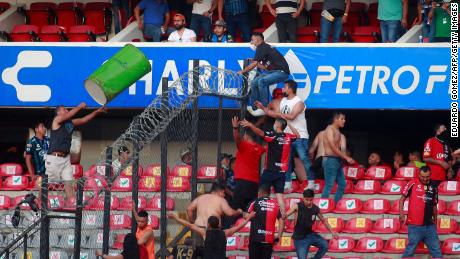 Fans clash in the stands during the match between Querétaro and Atlas.