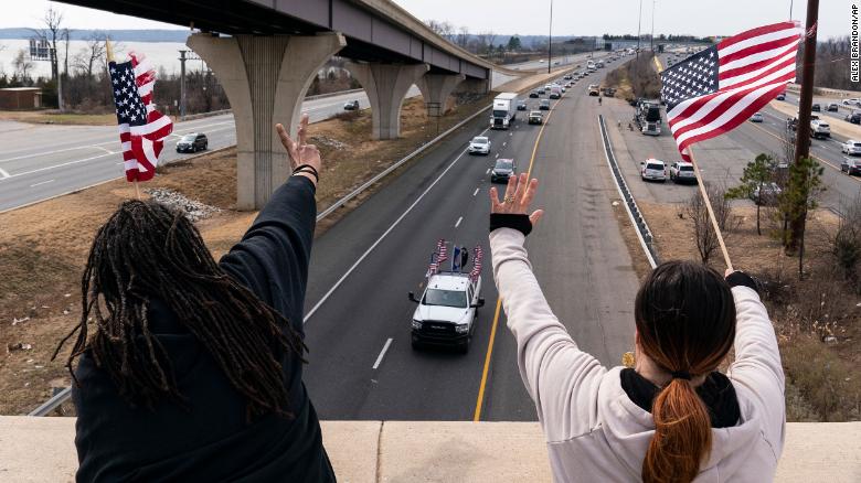 Mbështetësit tundin ndërsa një kolonë kamionësh dhe automjetesh të tjera udhëton I-495 pranë urës Woodrow Wilson, për të protestuar ndaj mandateve të Covid-19 dhe çështjeve të tjera të dielën, më 6 mars, në Fort Washington, Maryland.