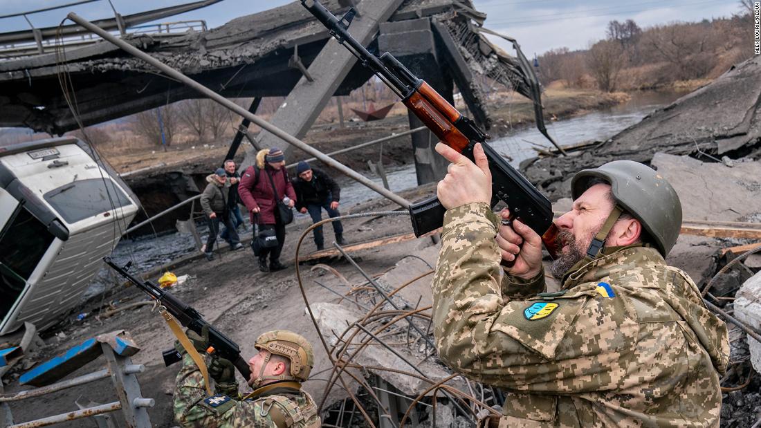 Ukrainian soldiers shoot at a Russian drone as civilians evacuate Irpin, Ukraine, on March 6.