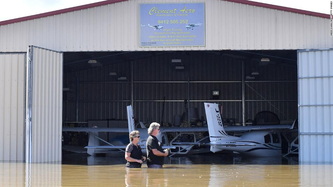Flying instructor Peter Clement, right, and his wife Kerrie stand in waist-high water as they examine their aircraft inside a flooded hanger at Grafton Air Strip in Grafton, Australia, on March 2.