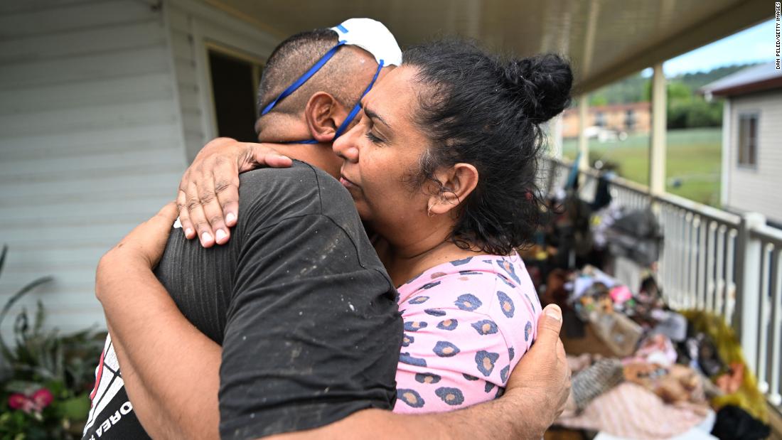 Michele Laurie hugs a work colleague who came to help in the cleanup of her home in Lismore on March 3.