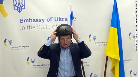 Yevgen Korniychuk, Ukraine&#39;s ambassador to Israel, puts on a protective helmet at a press conference on March 7. 