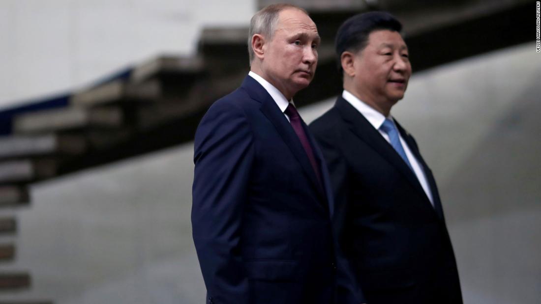 Russian President Vladimir Putin and Chinese leader Xi Jinping walk down the stairs as they arrive for a BRICS summit in Brasilia, Brazil in 2019. 