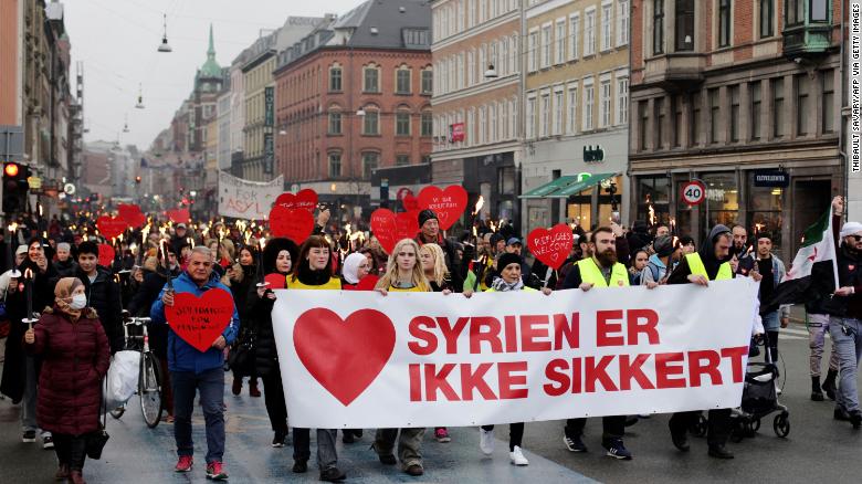 Demonstrators march with a banner reading &quot;Syria is not safe&quot; during a protest against the government&#39;s policy of returning some Syrian refugees in Copenhagen on November 13, 2021.