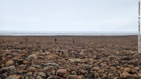 Para peneliti mengumpulkan sampel pasir dan batu di Greenland untuk menentukan kapan meteorit itu jatuh. 