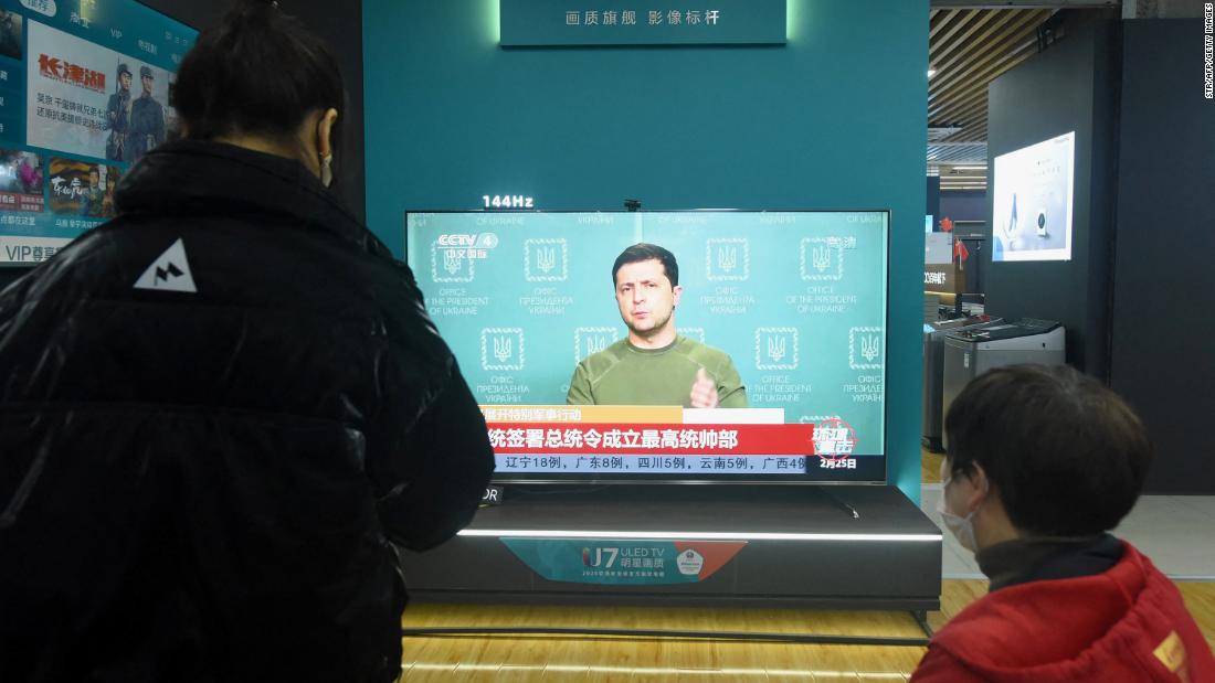 Residents watch a TV screen showing news about Ukraine at a shopping mall in Hangzhou, in China&#39;s eastern Zhejiang province on February 25, 2022.