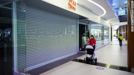 2022년 3월 4일 러시아 수도 베가스 쇼핑몰에서 쇼핑객들이 폐쇄된 H&M 매장을 지나고 있습니다.