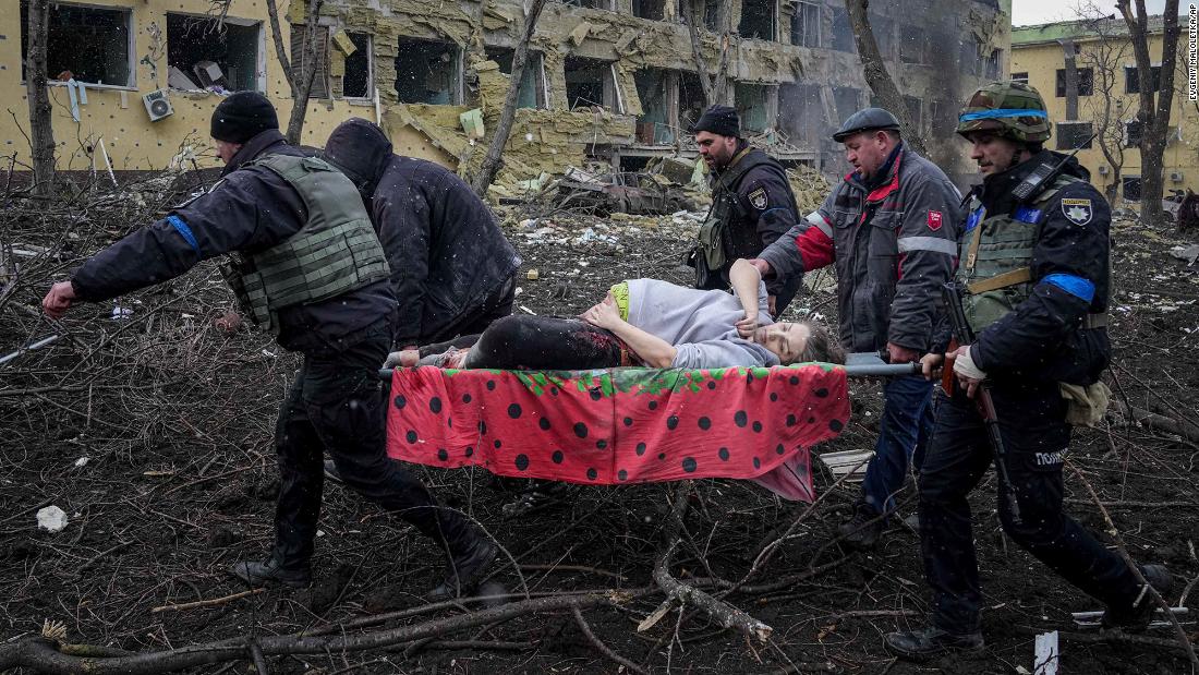 Ukrainian emergency workers carry an injured pregnant woman outside of a bombed maternity hospital in Mariupol, Ukraine, on Wednesday, March 9.