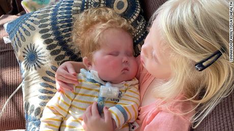 Ivy Sinnamon holds her brother, Easton, who needed a heart transplant because of a congenital disease.