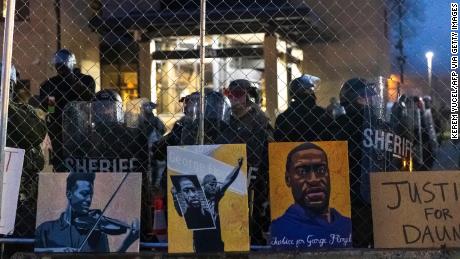 Pictures of Elijah McClain and George Floyd left by demonstrators line the fence outside a Minnesota police station in April 2021.