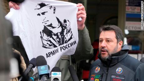 The mayor of Przemysl holds up a Vladimir Putin T-shirt as Matteo Salvini speaks to reporters on March 8, 2022. 