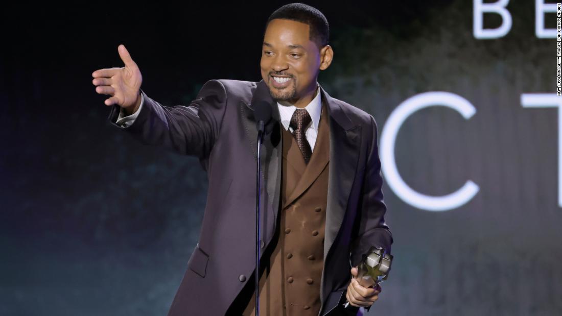 Will Smith accepts a best actor award for his role in the film &quot;King Richard.&quot;