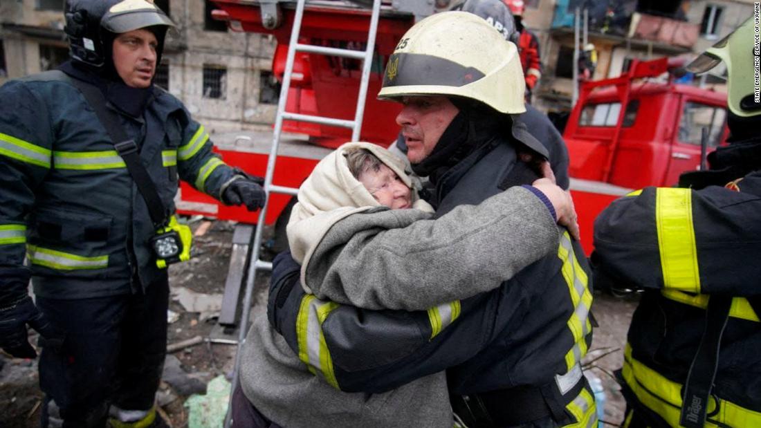 Rescuers in Kyiv help a woman evacuate a shelled residential building on March 14.
