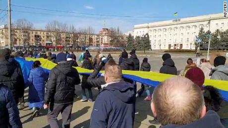 Live-streamed footage shows people carrying a banner in the colors of the Ukrainian flag as they protest amid Russia&#39;s invasion of Ukraine, in Kherson, on March 13.
