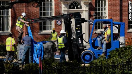 Workers removing the base of the Confederate statue on Monday. 