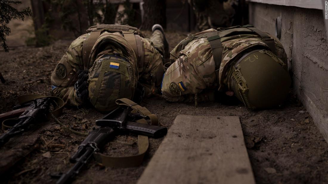 Ukrainian soldiers take cover from incoming artillery fire in Irpin, Ukraine, on March 13.