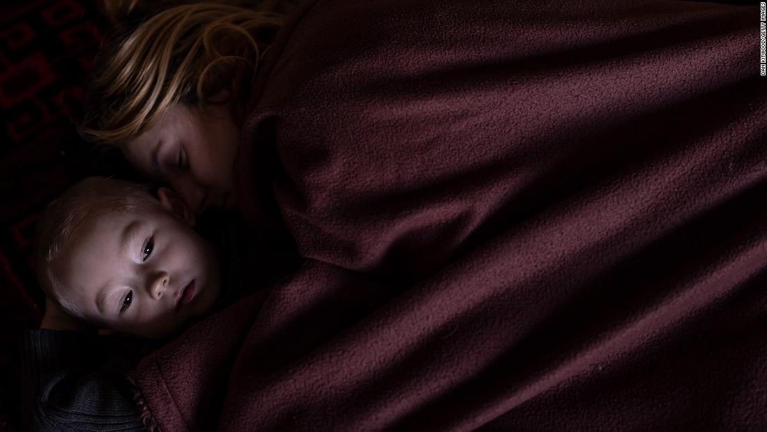 A mother and son rest in Lviv, Ukraine, while waiting to board a train to Poland on March 12.