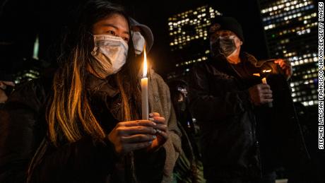 A woman holds a candle during a January 18 vigil in San Francisco for Michelle Go.