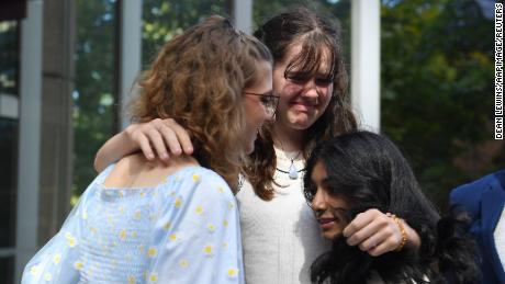 Ava Princi, 18, Luca Saunders, 16, and Anjali Sharma, 17, console each other after Tuesday's decision.   