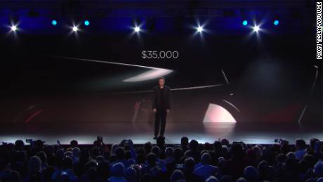 Elon Musk announcing the price of Tesla&#39;s Model 3 electric car during an unveiling event in 2016.
