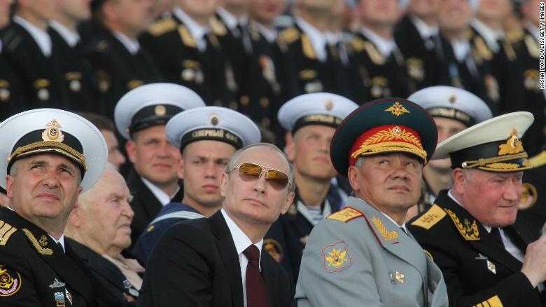 Russian President Vladimir Putin, center, and Defence Minister Sergei Shoigu, right, watch the Navy Day Military parade on July 27, 2014, at the main naval base of Severomorsk, Russia.