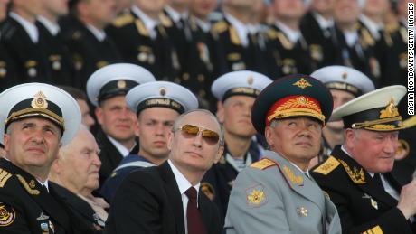 Russian President Vladimir Putin, center, and Defence Minister Sergei Shoigu, right, watch the Navy Day Military parade on July 27, 2014, at the main naval base of Severomorsk, Russia.