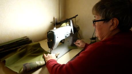 Irina Protchenko sews material for flak jackets in a corner of her living room in central Ukraine.