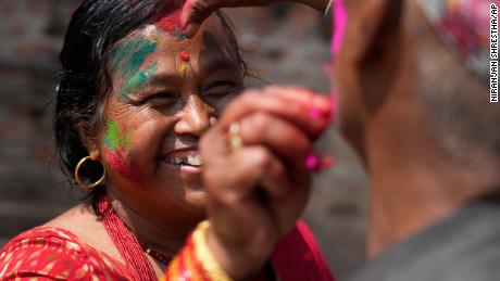 People apply colored powder on each other during Holi celebrations in Bhaktapur, Nepal on March 17, 2022.