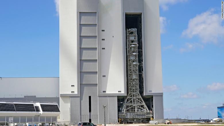 The rocket stack is seen inside the building before emerging on the crawler.