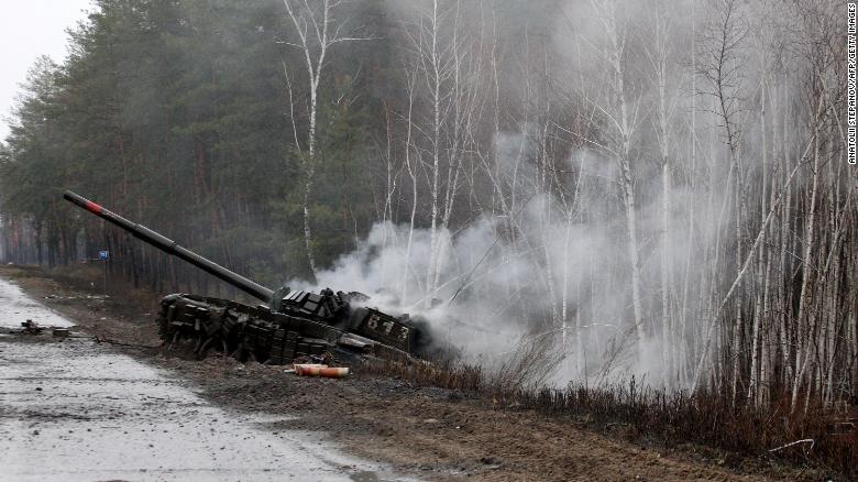 Smoke rises from a Russian tank destroyed by the Ukrainian forces on the side of a road in Lugansk region on February 26, 2022. Russia on February 26 ordered its troops to advance in Ukraine &quot;from all directions&quot; as the Ukrainian capital Kyiv imposed a blanket curfew.