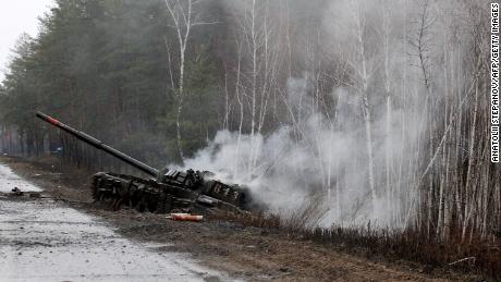 2022年2月26日、ルガンスク地域の道路沿いでウクライナ軍によって破壊されたロシアのタンクで煙が盛り上がっている。