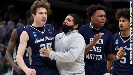 Doug Edert of the Saint Peter&#39;s Peacocks celebrates with his teammates after making a three-pointer against the Kentucky Wildcats.