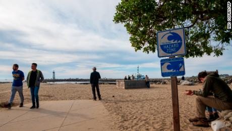 People watch waters rise from beaches in Santa Cruz, California, amid a tsunami advisory following the Tonga volcanic eruption.