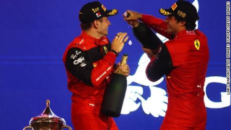 Leclerc and Carlos Sainz celebrate on the podium after securing a Ferrari one-two. 