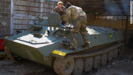 Soldados de las Fuerzas de Defensa Regionales de Ucrania inspeccionan un vehículo blindado de transporte de personal ruso capturado en el campo de batalla.