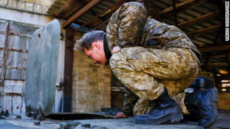 一名乌克兰士兵在一辆涂有乌克兰颜色的俄罗斯装甲运兵车内窥视。