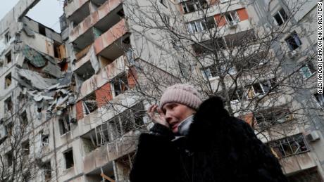 A Ukrainian woman near a block of apartment buildings destroyed in the besieged port city of Mariupol on March 17, 2022. 
