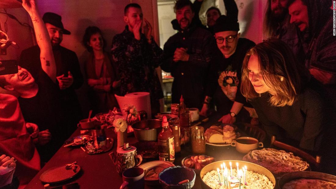 People share dinner and sing &quot;Happy Birthday&quot; during a celebration in Kyiv on March 20. This studio space has turned into a bomb shelter for approximately 25 artists who are volunteering to help the war effort. 